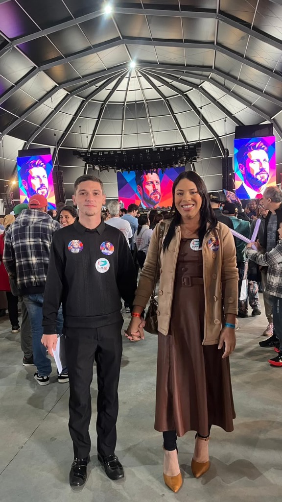 Mãe Danny e companheiro em evento político sob o domo.